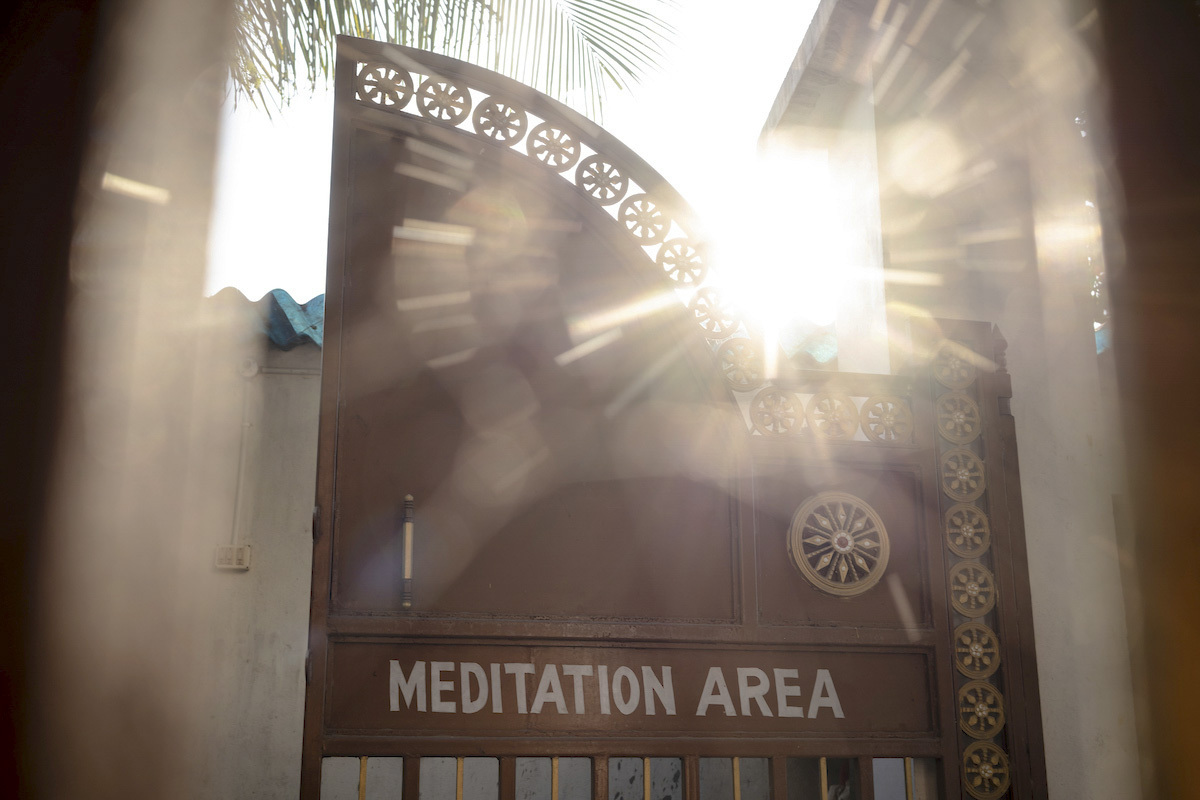 Rays of sunlight shining through the gate of a Vipassana Meditation Center.